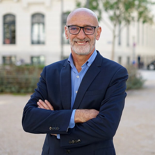 photographe portrait professionnel lyon – portrait corporate extérieur portrait professionnel à lyon en extérieur. dirigeant souriant en costume bleu, bras croisés. photographe portrait professionnel lyon spécialisé en portraits corporate.